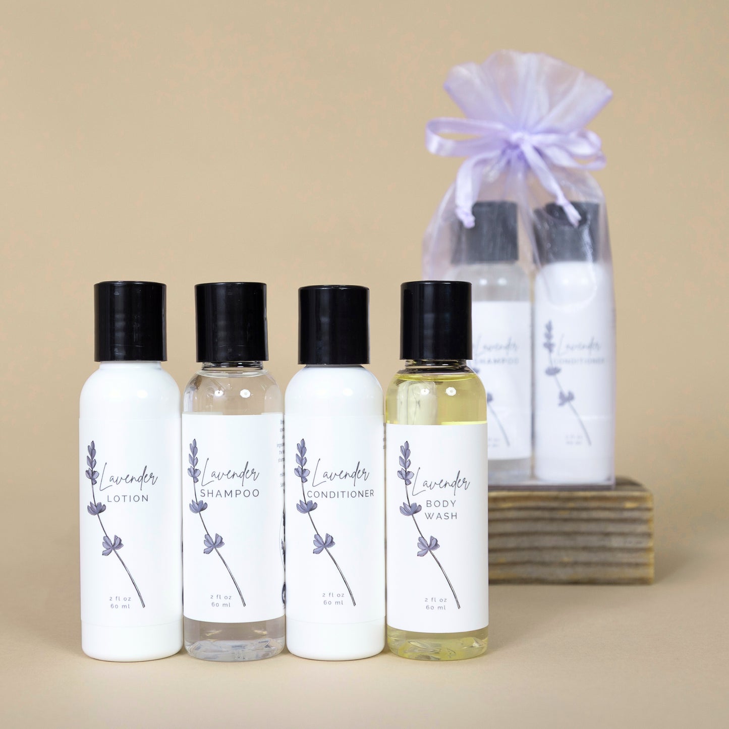 Set of lavender-themed skincare products including lotion, shampoo, conditioner, and body wash on a beige background.