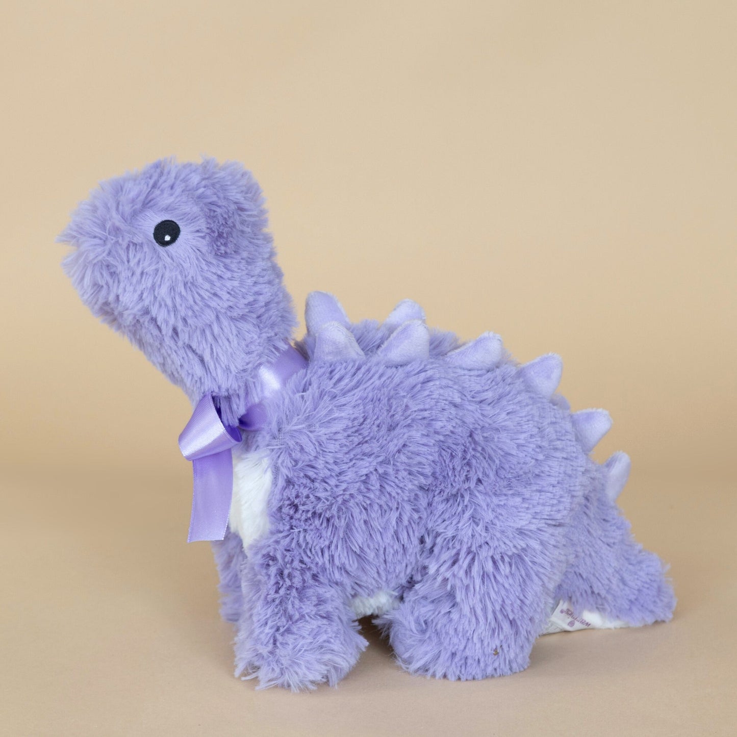 Lavender Aromatherapy Dinosaur plush in purple with a decorative bow, displayed for relaxation and comfort.