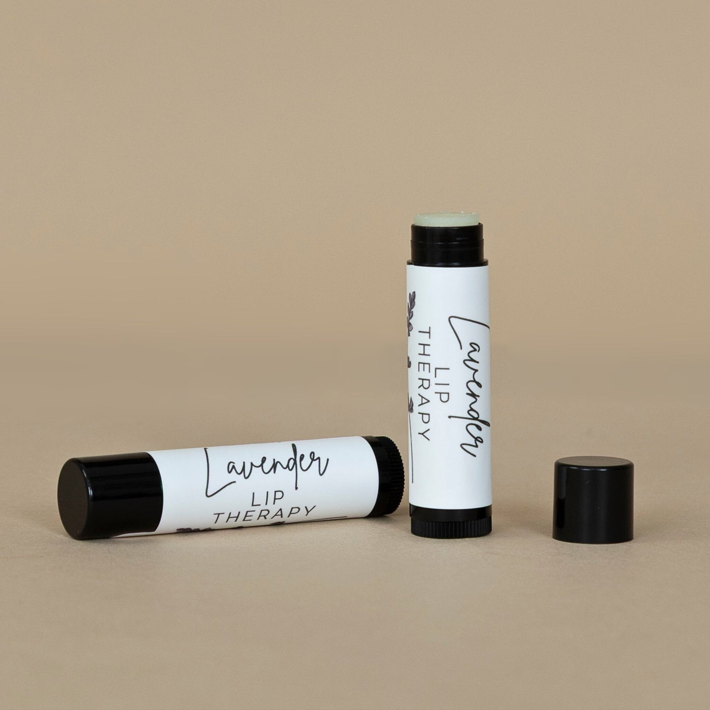 Lavender Lip Therapy arranged with fresh lavender sprigs, emphasizing the calming botanical ingredients of the lip balm.