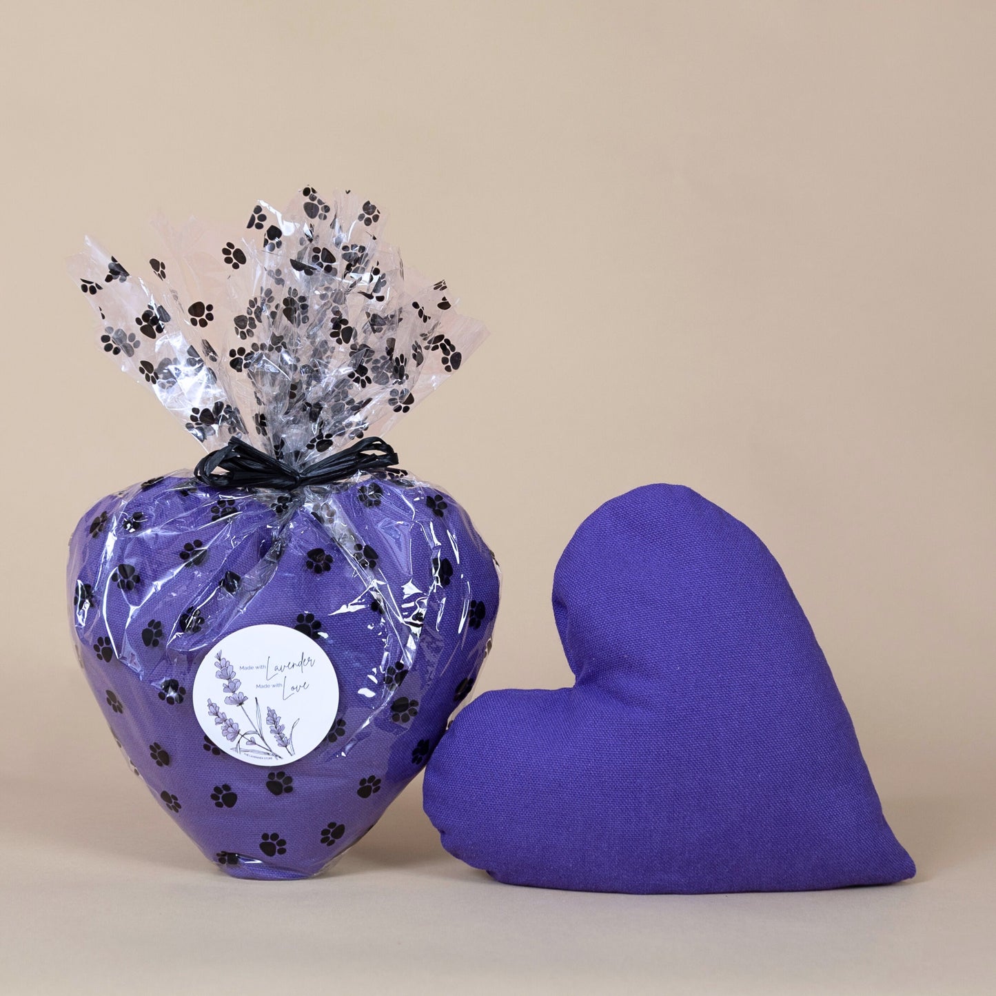 Lavender Pet Pillow presented as a purple wrapped gift with paw prints and a purple heart-shaped pillow on a beige background