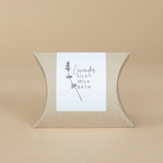 Lavender Silky Milk Bath jar opened to show the luxurious powder texture surrounded by natural spa elements.