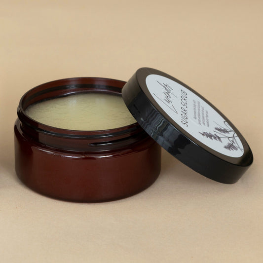 Lavender Sugar Scrub presented in an open jar with a wooden spoon, highlighting the scrub's texture