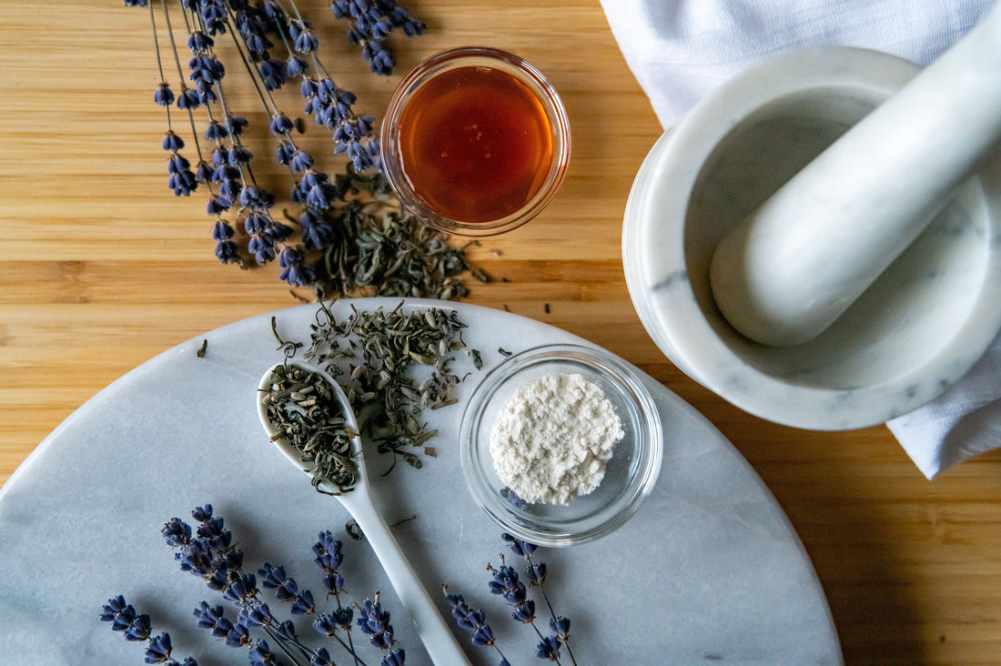 Herbal ingredients and a mortar and pestle on a wooden surface
