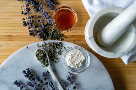 Herbal ingredients and a mortar and pestle on a wooden surface