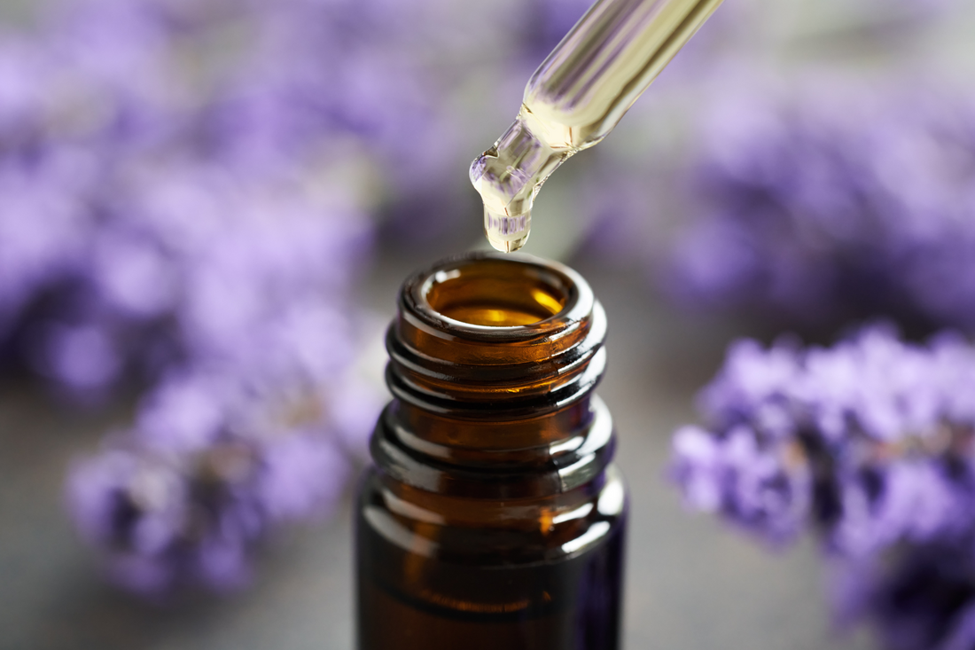 Pure lavender essential oil poured into a brown glass bottle