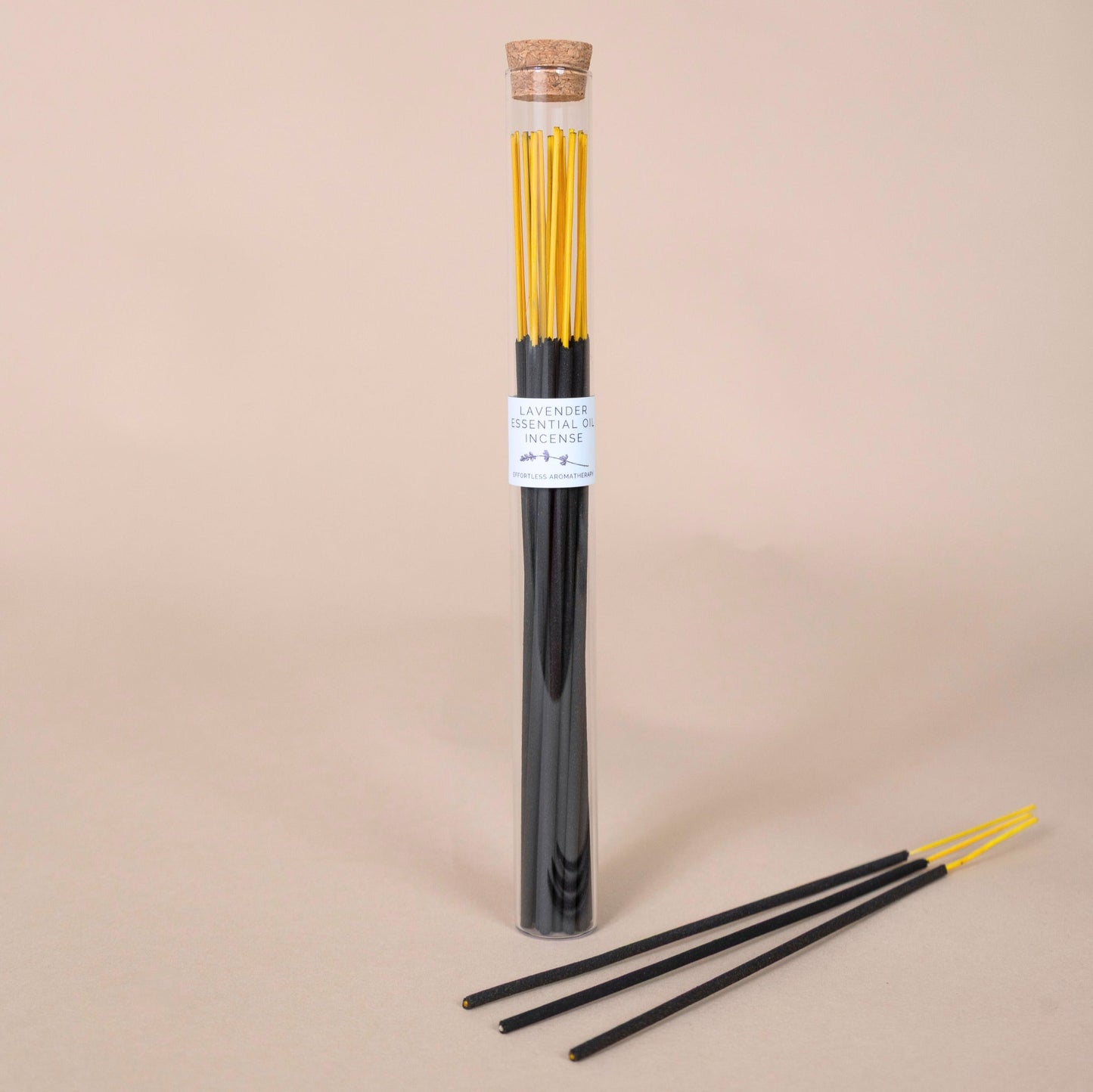 Lavender Incense Sticks tube with three incense sticks arranged in front on a beige surface