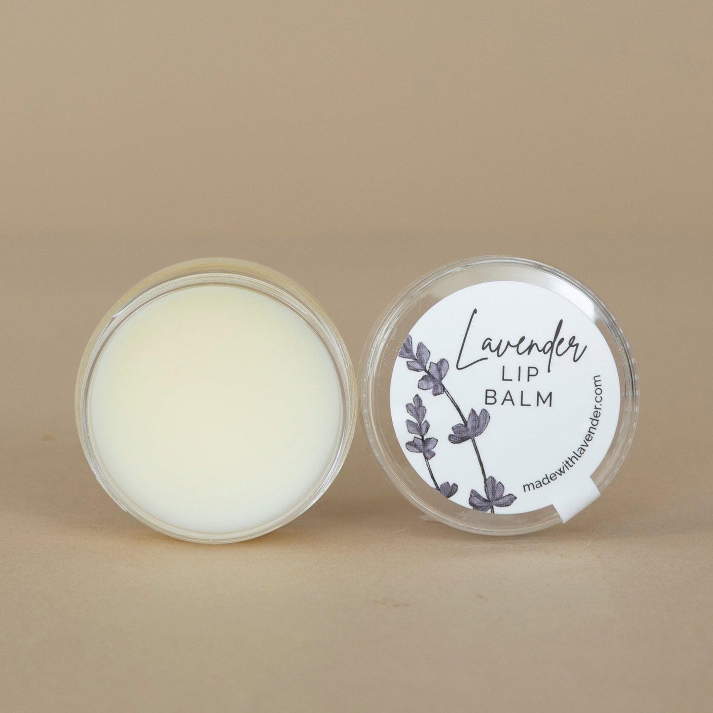 Lavender Lip Balm shown with cap removed to highlight the creamy texture and pale lavender hue