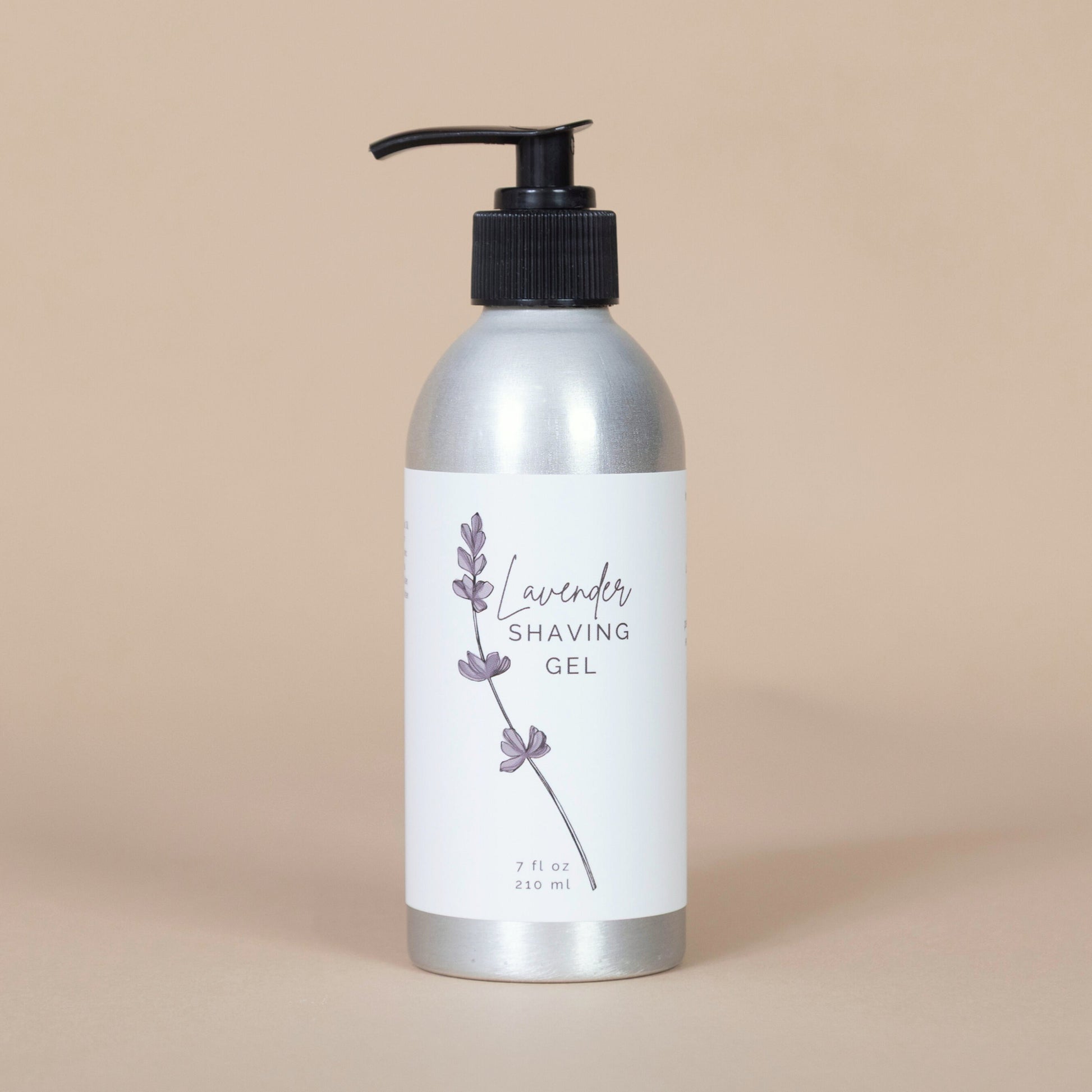 Silver metal bottle of lavender shaving gel on a beige background