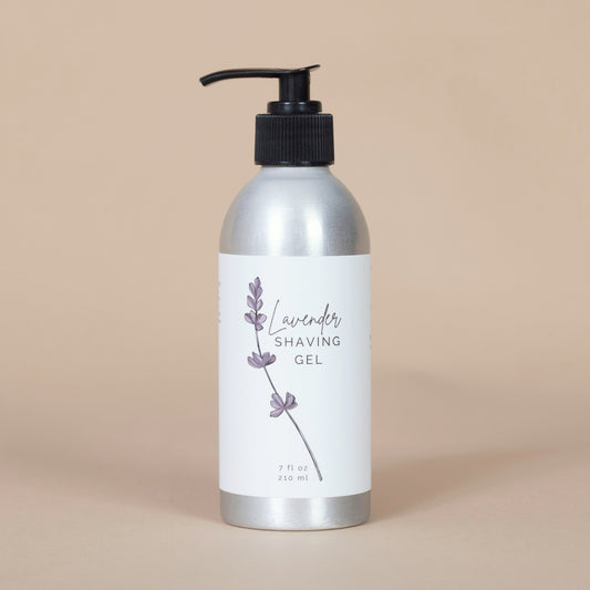 Silver metal bottle of lavender shaving gel on a beige background