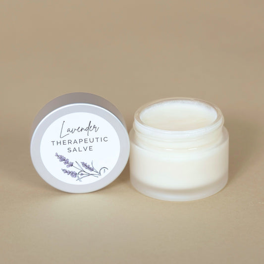 Lavender Therapeutic Salve jar with a white lid displayed on a beige background, showcasing the soothing product packaging
