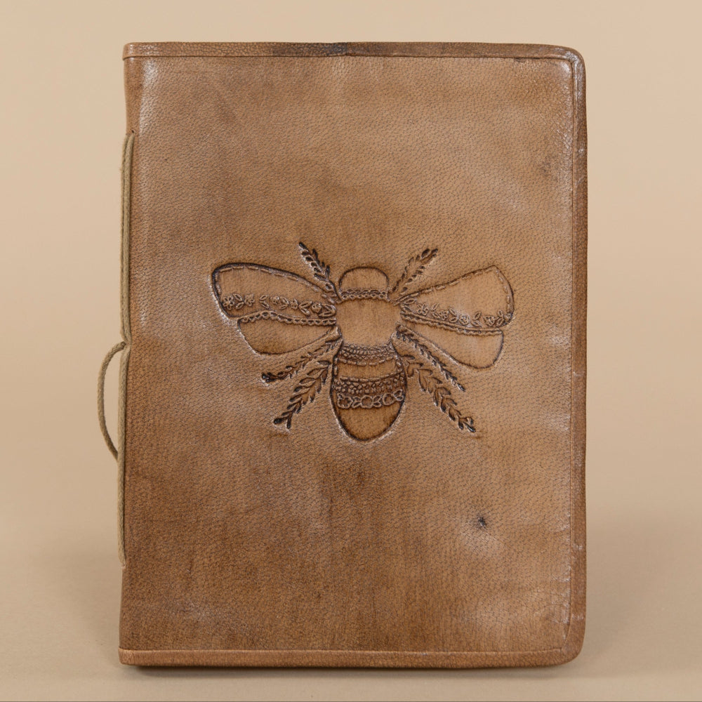 Open Leather Bee Journal displaying lavender bee embossed cover and smooth blank pages, perfect for writing or sketches.