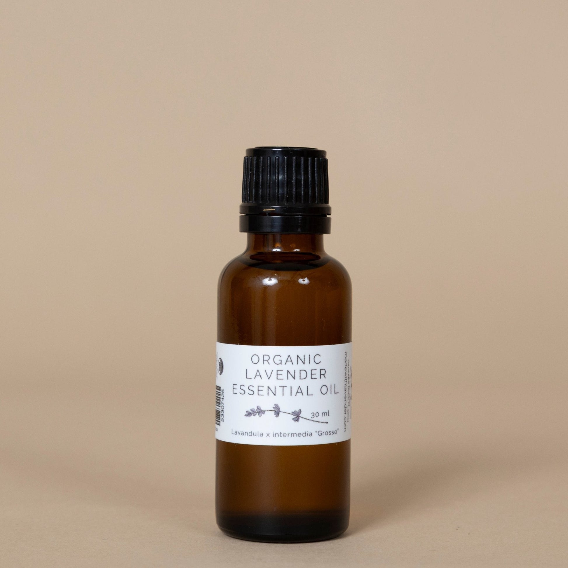 Organic Lavender Essential Oil presented with a minimalist label, placed among aromatic dried lavender flowers