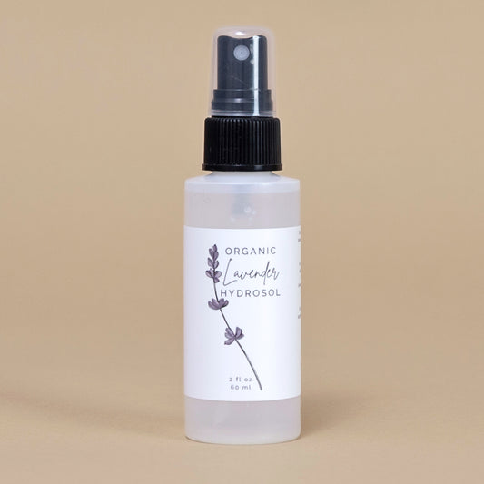 Frosted white bottle of organic lavender hydrosol on a beige backgrouud