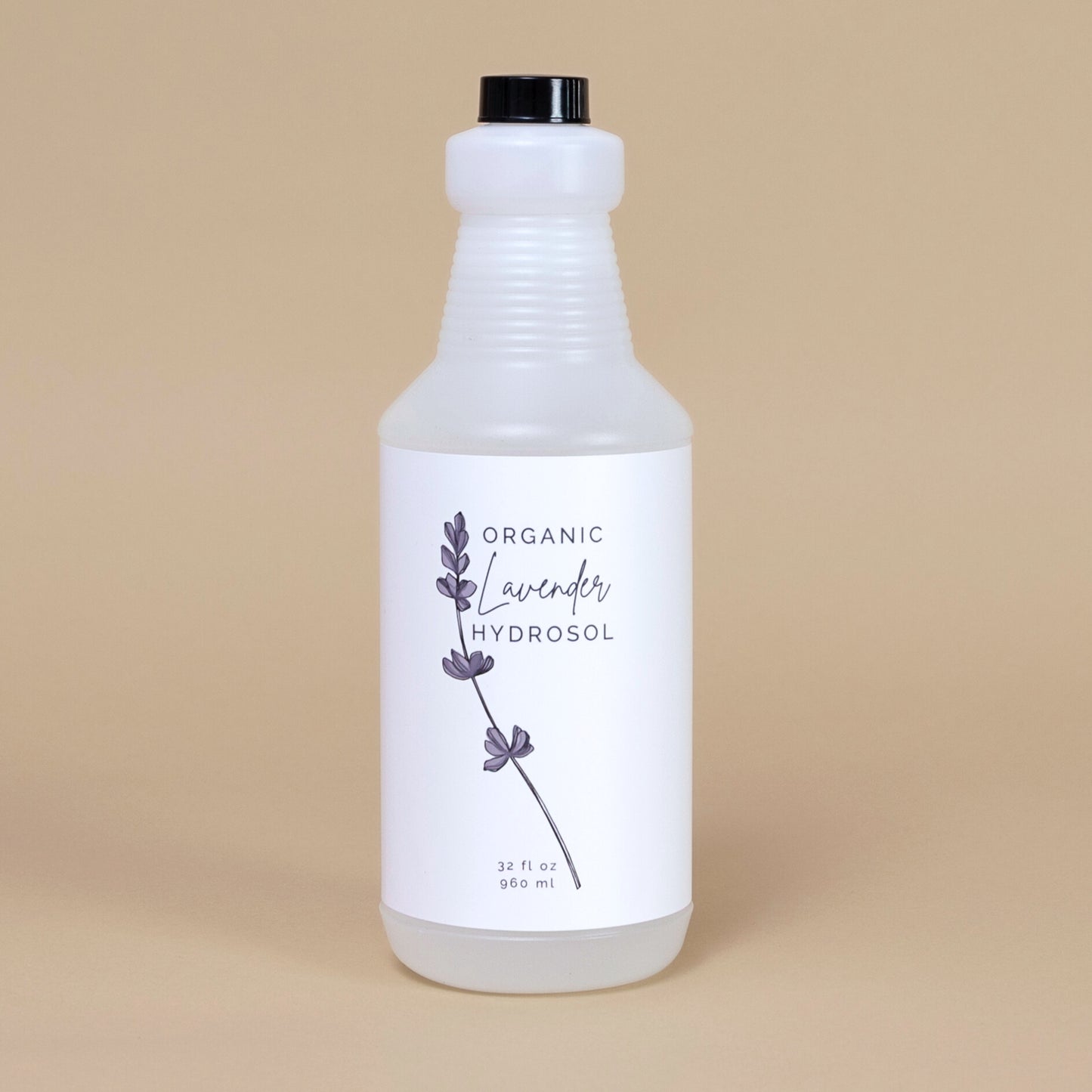 Frosted white bottle of organic lavender hydrosol on a beige backgrouud