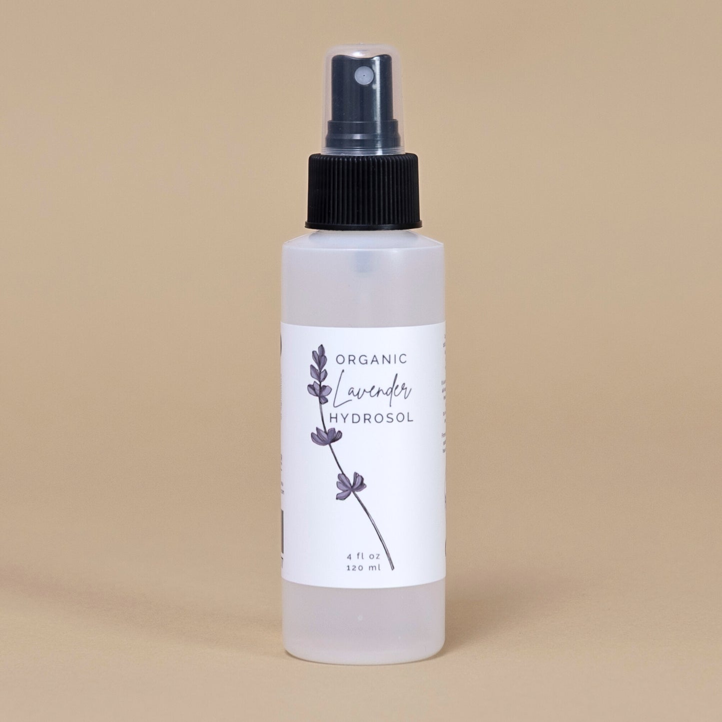 Frosted white bottle of organic lavender hydrosol on a beige backgrouud