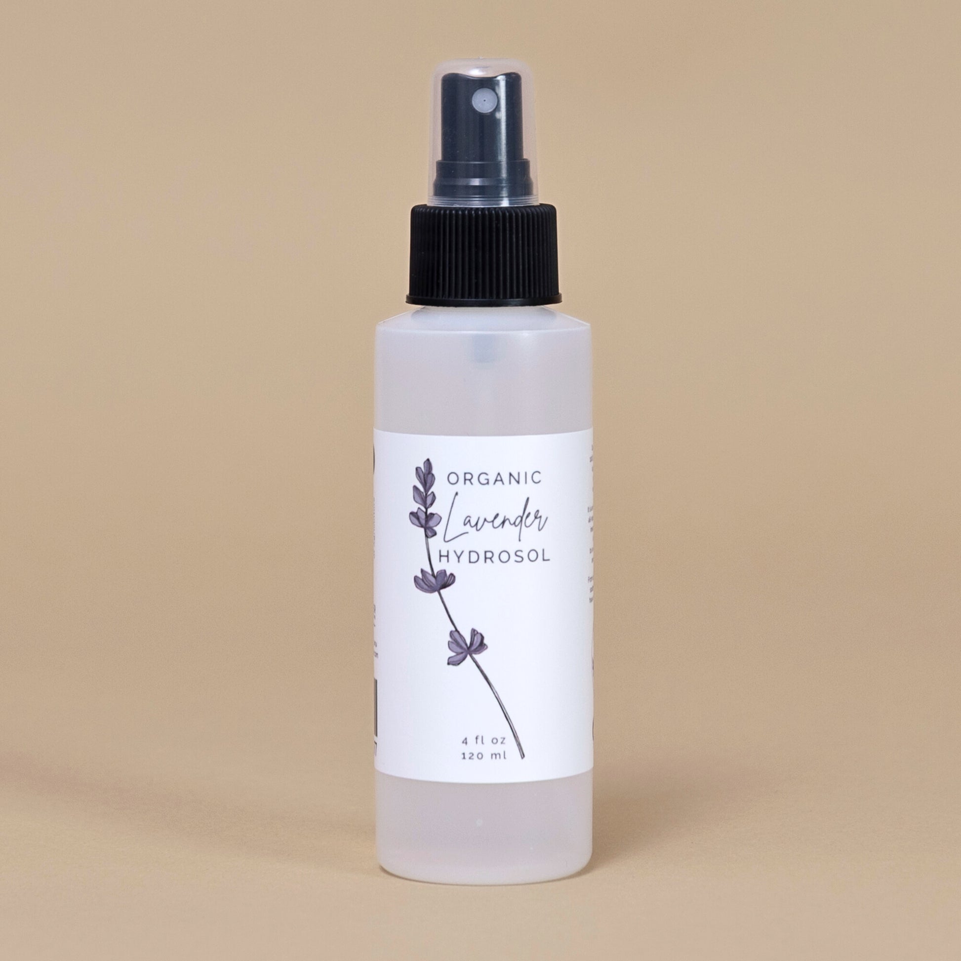 Frosted white bottle of organic lavender hydrosol on a beige backgrouud