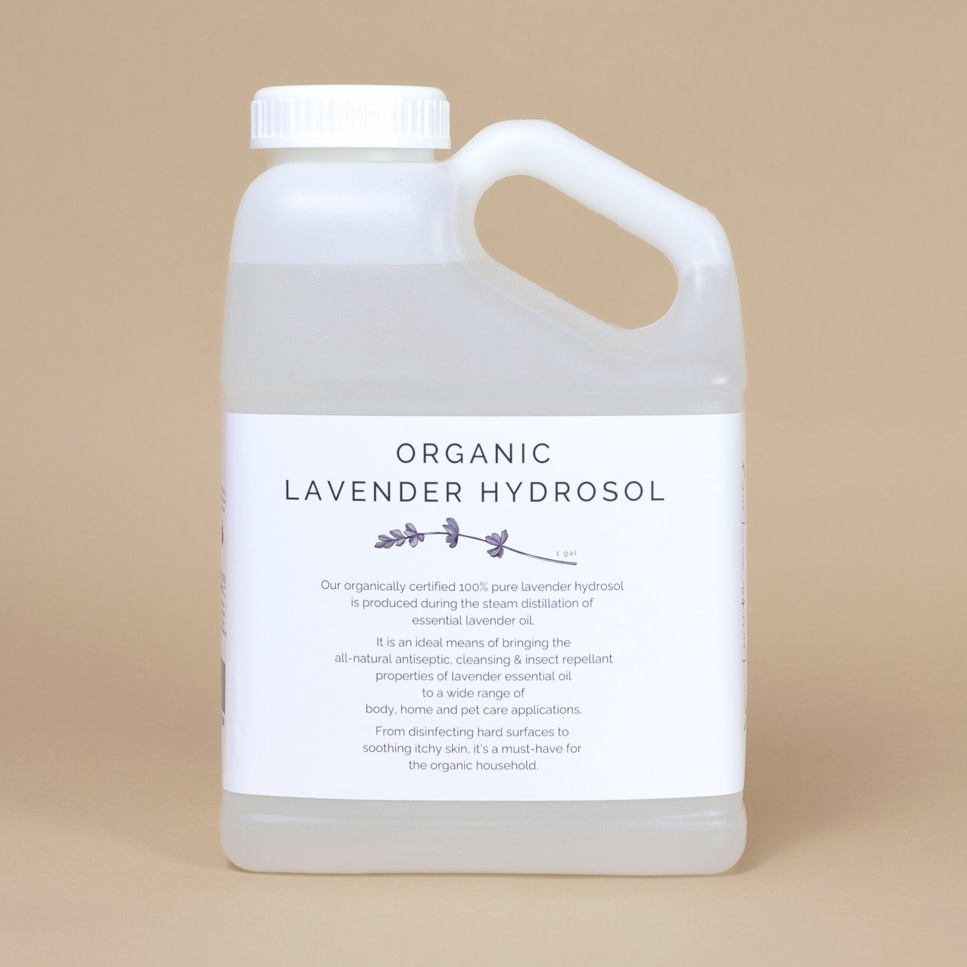 Frosted white bottle of organic lavender hydrosol on a beige backgrouud