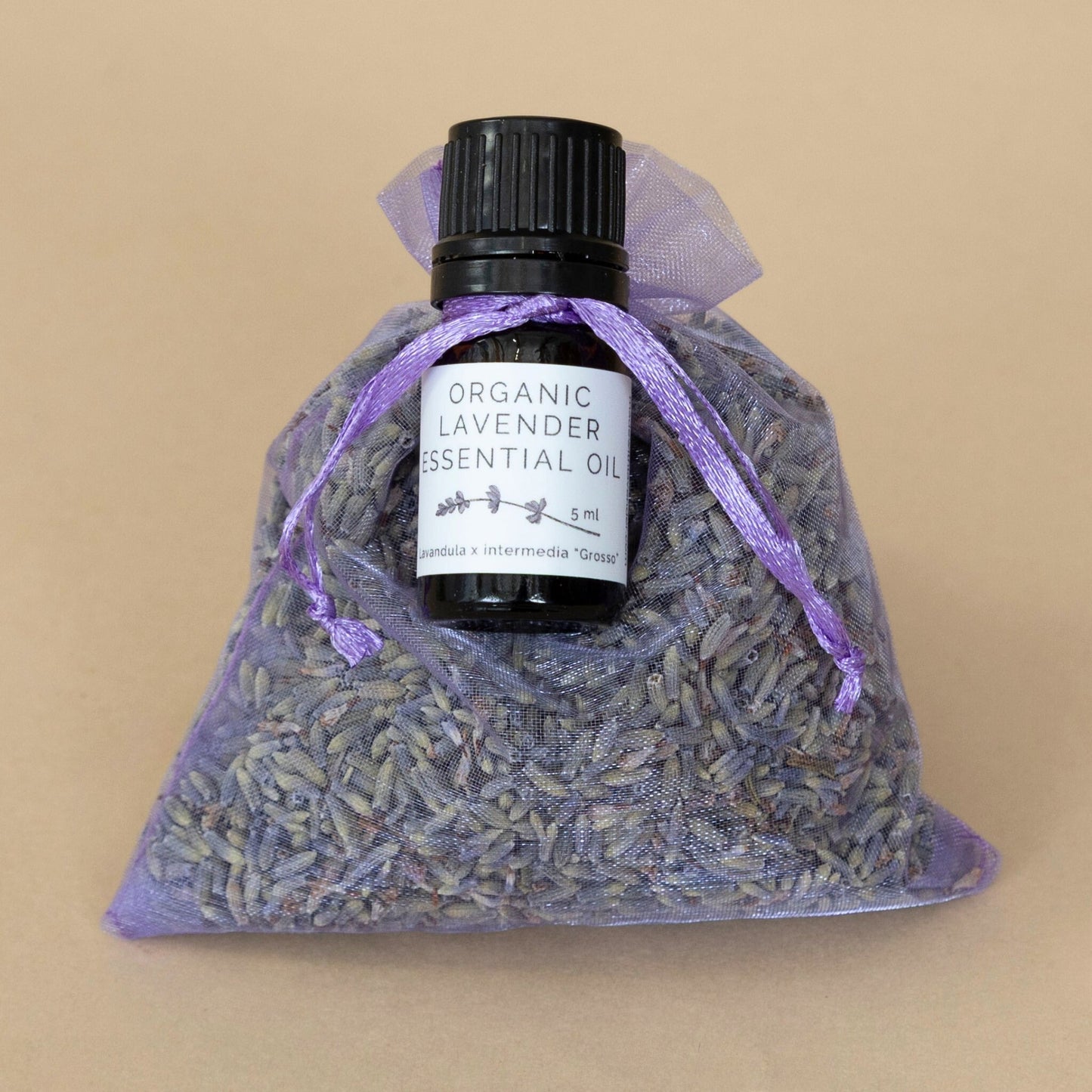 Organic Lavender Sachet and Essential Oil beautifully displayed together with calming purple hues and natural textures.