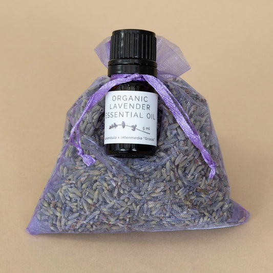 Organic Lavender Sachet and Essential Oil beautifully displayed together with calming purple hues and natural textures.
